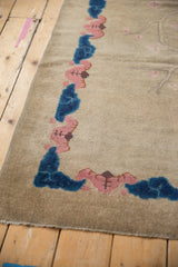 Corner view of antique Art Deco rug, beige field, cobalt blue and blush cloud border.