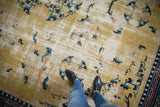 Saffron yellow field of antique Chinese Ningxia carpet, wear, dancing floral motifs in blues.