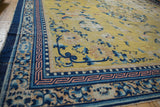 Antique Ningxia carpet corner with saffron field, blue florals, Greek key, and pearl borders.