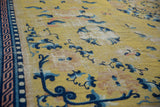 Saffron field of antique Ningxia carpet, blue floral vines, geometric border, visible foundation.