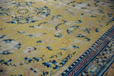Collector's antique Ningxia carpet: saffron field, cobalt blue floral motifs, geometric border.
