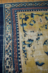 Antique Ningxia rug corner: saffron field, cobalt floral motifs, geometric and pearl borders, foundation showing.