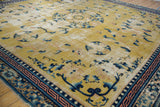 Saffron field, blue floral motifs, and distinctive pale copper geometric border.