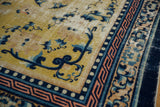 Antique Ningxia rug detail: saffron field, cobalt floral motifs, pearl and copper key borders, visible wear.
