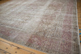 Distressed corner of a vintage Tabriz showing low pile wear and muted floral border details.