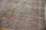 Textured wear on a vintage Tabriz rug showing exposed knot heads and the woven foundation.