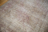 Low pile texture of the distressed Tabriz carpet with time-softened purple and ivory hues.