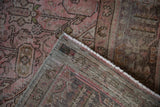 Distressed pink and brown pile of a vintage Northwest Persian carpet showing hand-knotted foundation.