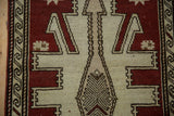 Distressed Oushak runner's chestnut geometric pattern and ivory reciprocating wave border.