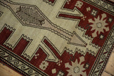 Distressed Oushak runner detail: chestnut, ivory geometric and starburst motifs, wave border.