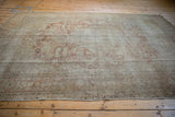 Distressed Kayseri carpet's secured end, with faded rose patterns and visible foundation.
