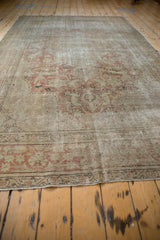 Distressed lower border of the Kayseri carpet showing dusty rose floral pattern and visible foundation.