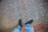 Vintage distressed Kayseri rug, displaying faded red, beige, yellow curvilinear pattern.
