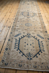 Angled perspective view down the distressed vintage Karaja runner's repeating geometric medallions.