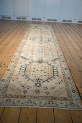 Angled view down the length of a distressed Karaja runner with navy and sand geometric medallions.