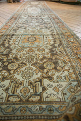 Distressed Malayer runner showing worn pile, antique ivory, soft blue, and rust floral patterns.