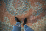 Decorative worn texture of vintage Khoy rug, faded tangerine and dusty blue design.