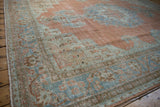 Distressed texture of the vintage Khoy rug with faded tangerine and dusty blue.
