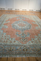 Vintage Khoy carpet detail: distressed dusty tangerine and pale seafoam pile, faint foundation.