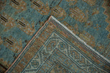 Distressed Serbend rug corner detail: abrashed aquatic blue pile, tightly woven foundation, and pink side cord.