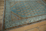 Distressed Serbend rug corner, showcasing its meandering vine main border details.