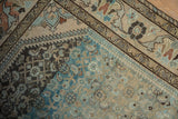Meandering vine border contrasts with the worn Herati field in charcoal and dusty powder blue.
