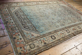 A vintage distressed Borchalou rug's meandering vine border frames the softly worn Herati field.