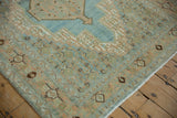 Distressed vintage Bibikabad rug corner, with samovar turtle border and Herati field motifs in soft blue and apricot.