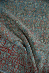 Distressed Malayer rug corner, soft brick red germinating floral border, blue Herati field.