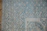 Vintage distressed Ersari rug's geometric border, short pile, cream and dusty blue colors.