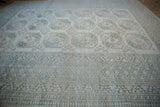 Distressed Ersari carpet's geometric border with serrated and diamond patterns in dusty teal.