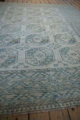 Vintage distressed Ersari carpet's geometric border with serrated patterns, cream, dusty teal, and short fringe.