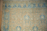 Close-up on the even wear and low pile of the vintage Hamadan rug's corner and border.