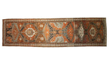 Distressed vintage Malayer runner with dramatic geometric medallions in chestnut, charcoal, and ivory.