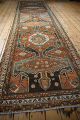Distressed Malayer runner detail featuring geometric medallion, vinery, and florals in chestnut, rust, charcoal.