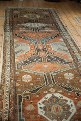 Central medallion and bird motifs on a distressed Malayer runner with chestnut and charcoal tones.