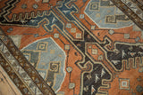 Close-up of distressed Malayer rug runner featuring copper field, charcoal patterns, and bird motifs.