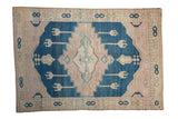 Distressed vintage Oushak rug with dusty cobalt blue abrashed field and pale mauve geometric motifs.