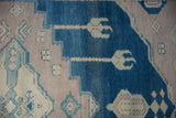Distressed Oushak rug showing abrashed dusty cobalt blue and pale mauve geometric pattern.