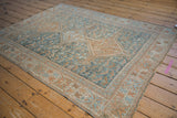 Vintage Distressed Qashqai rug corner with pale teal and copper geometric border, showing even knot wear.