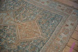 Even wear and distressed texture of a vintage Qashqai rug in pale copper and teal blue.