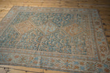 Distressed Qashqai rug corner, geometric borders, field in faded teal and copper.