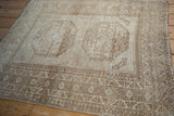 Distressed Ersari rug detail shows paneled gul design and geometric borders in soft beige, cream, and ivory.