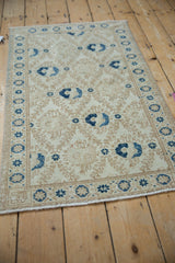 Distressed ivory Turkish Sparta rug with pale coffee lattice and navy cobalt blue bird motifs.