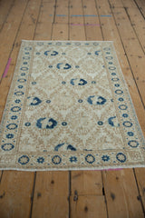 Distressed Turkish Sparta rug's worn border and lattice floral bird motifs in navy, sand, ivory.