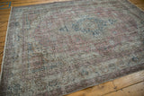 Distressed texture of vintage Sparta carpet with faded floral motifs in dusty raspberry and oxidized silver.
