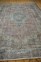 Distressed vintage Sparta carpet showing low pile texture, faded patterns, dusty raspberry and navy.