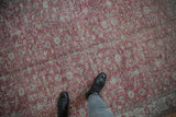Vintage distressed Sparta carpet's faded cochineal red pile and floral design underfoot.