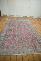 Faded cochineal red vintage Sparta carpet with distressed scrolling floral patterns.
