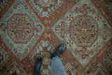 Geometric medallions and hook-and-latch motifs in chestnut and powder blue on a vintage carpet.